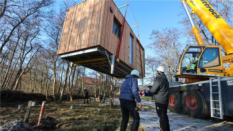 Mit einem Kran werden die Tiny Houses in Position gebracht.
