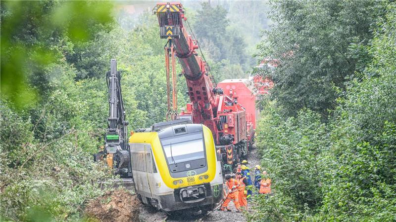Mit einem Kran wird an der Unfallstelle, an der ein Regionalzug entgleist ist, gearbeitet. Ein Regionalexpress war am Sonntagabend (27.07.2025) in Riedlingen nach bisherigen Erkenntnissen infolge eines Hangrutsches entgleist.