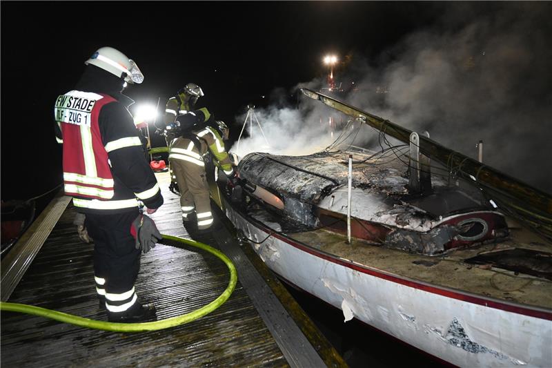 Feuer zerstört Segeljacht im Stader Holzhafen – Polizei ermittelt Mit einem Spezialmittel werden in der Nacht zu Dienstag die letzten Brandnester auf der Segeljacht im Stader Holzhafen bekämpft. Foto: Vasel