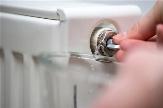 Mit einem Vierkantschlüssel das Ventil an der Seite des Heizkörpers öffnen und so lange offen lassen, bis die Luft entwichen ist und nur noch Wasser nachkommt. Foto: dpa-tmn