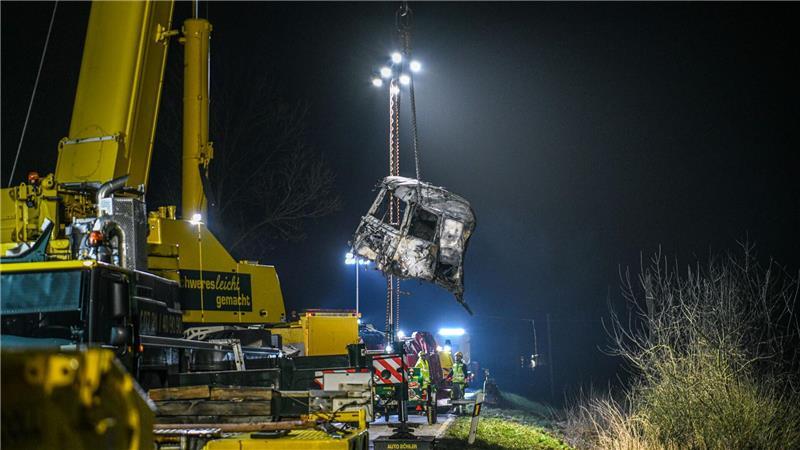 Mit einem großen Kran und unter Flutlicht werden Trümmerteile geborgen. 