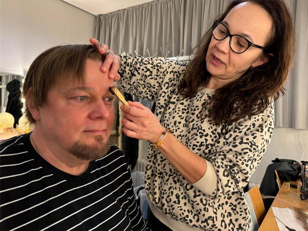 Mit einer Bürste trägt Maskenbildnerin Beata Rolkowska dunkle Farbe auf Münchows...