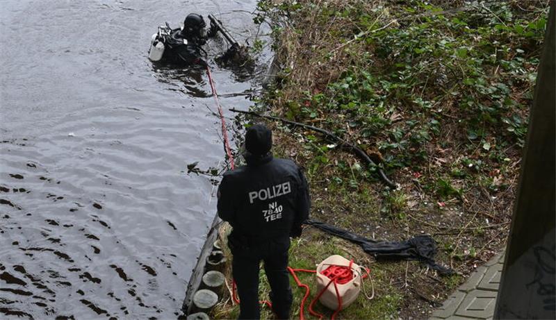 Mit ihren Händen tasten die Taucher der Polizei den Uferbereich ab.