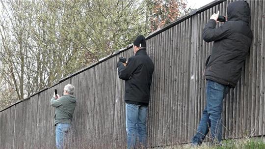Schaulustige fotografieren und filmen einen Einsatz an einer Unfallstelle.