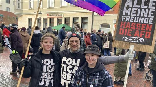 Mit kohlegeschwärztem Gesicht, Plakat und T-Shirts des „Zentrums für politische Schönheit" sind Emily, Antonio und Milo Morais gekommen.