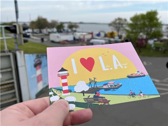 Mit neuen Ansichtskarten der Berliner Grafikerin Saskia Radtke wollen Tourist-Info und Lille Lispeltute für das Alte Land werben. Damit noch mehr Ausflügler eine Liebeserklärung für den Lühe-Anleger („L.A.“) abgeben, will die Politik diesen