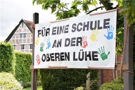Mit solchen Plakaten werben die Anwohner an der Oberen Lühe für den Erhalt des Schulstandortes. Fotos: Battmer