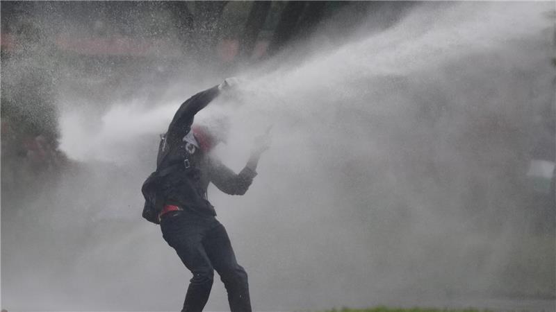 Mit voller Wucht: Ein Demonstrant wird bei Protesten gegen die Politik von Präsident Petro von einem Wasserwerfer getroffen.