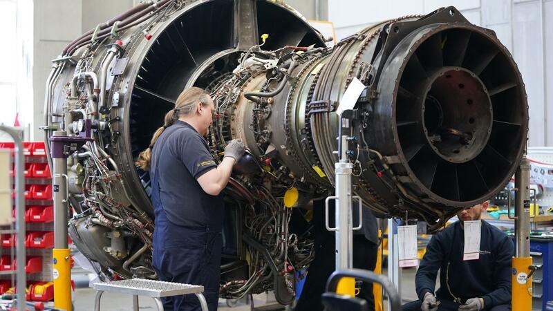 Mitarbeiter arbeiten an einer Flugzeugturbine in der Triebwerksüberholungswerkstatt auf dem Gelände der Lufthansa Technik AG.