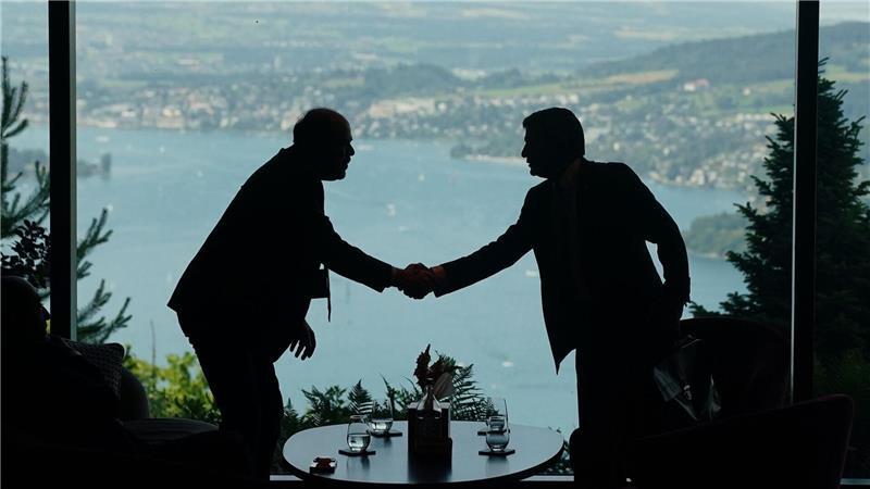 Mitarbeiter der Delegationen geben sich im Rahmen eines Treffens zwischen den USA, dem Iran, Pakistan und Katar die Hand.