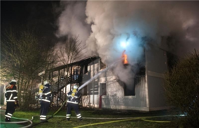 Mitarbeiter der Feuerwehr löschen im Stadtteil Billstedt den Brand in einer Wohnunterkunft für Flüchtlinge. Foto: Daniel Bockwoldt/dpa