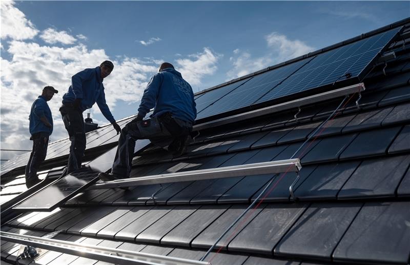 Mitarbeiter der Firma Sontec GmbH montieren Photovoltaikmodule auf dem Dach eines Wohnhauses . Auch in Sauensiek soll der Einsatz regenerativer Energie geprüft werden. Fotos: Marijan Murat/dpa/Lepél
