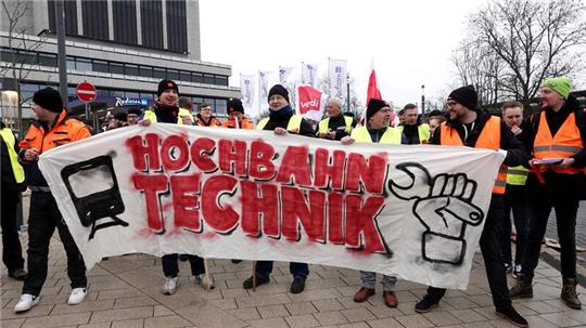 Mitarbeiter der Hamburger Hochbahn halten ein Transparent mit der Aufschrift „Hochbahn Technik“.