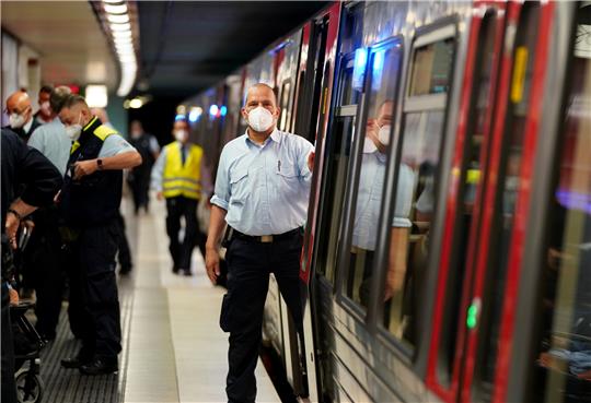 Mitarbeiter der Hochbahn-Wache kontrollieren die Maskenpflicht in den ankommenden Zügen im U-Bahnhof Burgstraße in Hamburg. Foto: Marcus Brandt/dpa