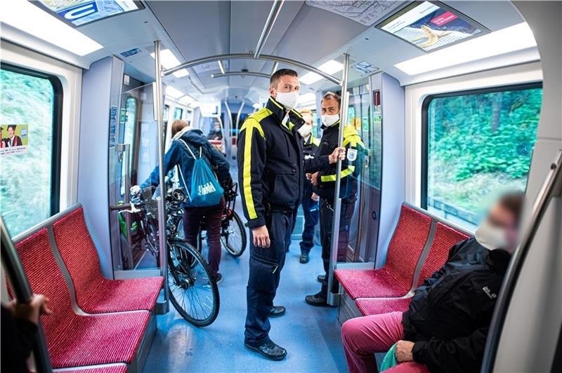 Mitarbeiter der Hochbahn-Wache kontrollieren die Einhaltung der Maskenpflicht in einer U-Bahn. Foto: Reinhardt/dpa