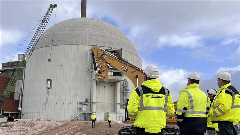 AKW-Rückbau in Stade: Kleine Abrissbirne mit sehr großer Wirkung Mitarbeiter der am Rückbau beteiligten Firmen verfolgen das Spektakel am Dienstagmittag. Jetzt geht es der weithin sichtbaren AKW-Betonkuppel an den Kragen.