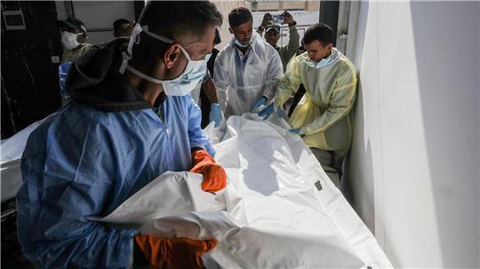 Mitarbeiter des Roten Kreuzes nehmen die Leichen nicht identifizierter Palästinenser in Empfang.