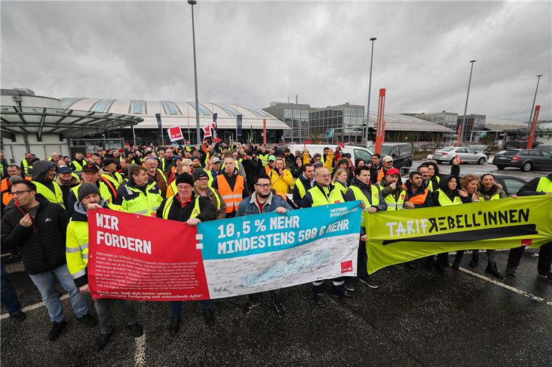 Flughafen Hamburg wieder im Normalbetrieb Mitarbeiterinnen und Mitarbeiter verschiedener Firmen am Airport Hamburg kommen auf einem Parkdeck am Flughafen zu einer Verdi-Kundgebung während ihres Warnstreiks zusammen. Am Flughafen Hamburg hat der Streik am Sonntag, 12. März, um 22:00 Uhr begonnen. Foto: Christian Charisius/dpa