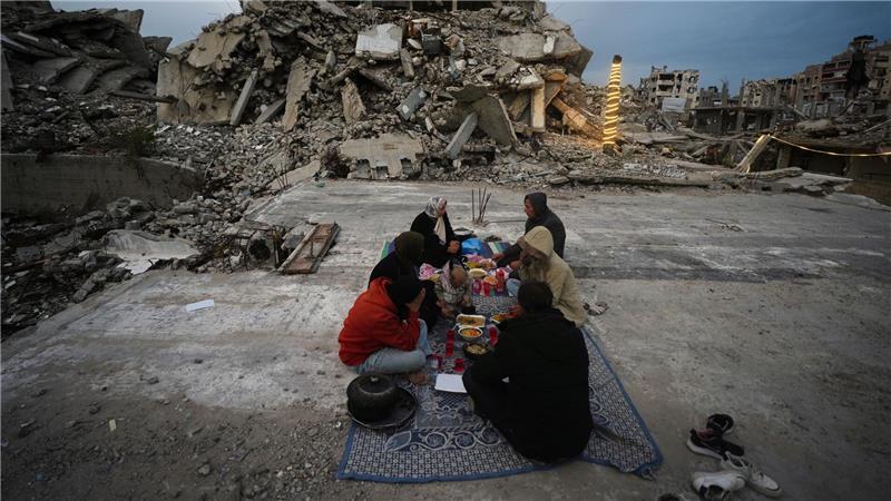 Mitglieder der Familie Al-Najar brechen ihr Fasten während des muslimischen heiligen Monats Ramadan inmitten der Trümmer zerstörter Gebäude im Gazastreifen.