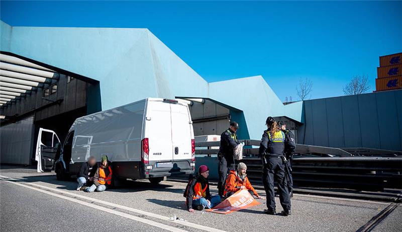 Klimaaktivisten bringen Autoverkehr durch Hamburg zum Erliegen Mitglieder der "Letzten Generation" haben sich auf der Fahrbahn der Autobahn 7 festgeklebt und blockieren so die Zufahrt des Elbtunnels in Richtung Norden. Foto: Daniel Bockwoldt/dpa