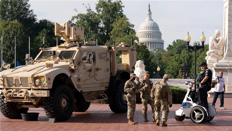Bilder des Tages Mitglieder der Nationalgarde, die auf Anordnung von Präsident Trump in der US-Hauptstadt Washington sind, stehen neben einem gepanzerten Fahrzeug.