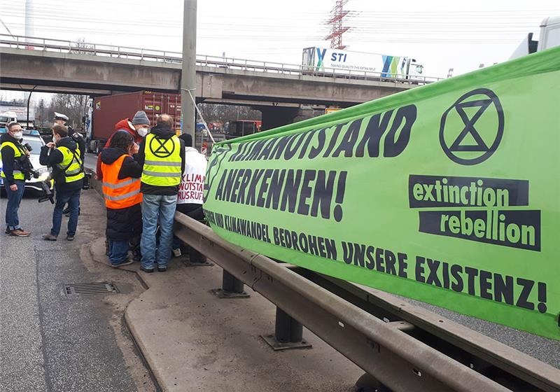 Mitglieder der Umweltschutzbewegung Extinction Rebellion protestieren an der für den Warenverkehr aus dem Hamburger Hafen wichtigen Köhlbrandbrücke gegen Umweltbelastungen durch den Verkehr. Foto: Markus Kleinknecht/dpa-TNN/dpa