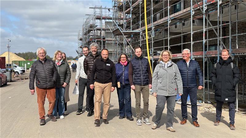 Mitglieder des Wirtschaftsvereins Buxtehude gehen bei einer exklusiven Führung über die Baustelle des Orchideenquartiers den Moosbeerenweg entlang.
