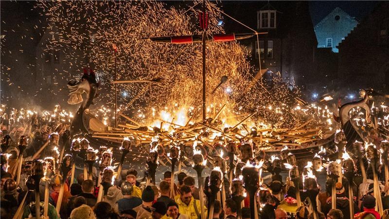 Mitglieder vom Jarl Squad zünden eine Galeere in Lerwick auf den Shetlandinseln während des Up Helly Aa-Festivals an. 