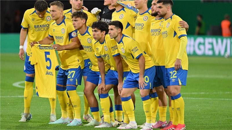 Schock nach Pokal-Aus: Braunschweig-Profi erneut verletzt Mitleid mit dem Teamkollegen: Die Braunschweiger halten vor dem Pokalspiel gegen Stuttgart ein Trikot des verletzten Frederik Jäkel hoch.