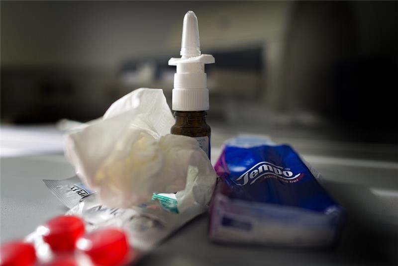 Mittel gegen Erkältung wie Nasenspray, Halstabletten und Papiertaschentücher liegen auf einem Tisch. Foto: Arno Burgi/dpa-Zentralbild/dpa