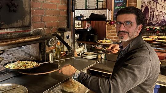 Mojtaba Abadi, Inhaber des Restaurants Amadeus in Buxtehude, bereitet Pizza im Ofen zu. Zu Weihnachten bewirtet er Bedürftige.