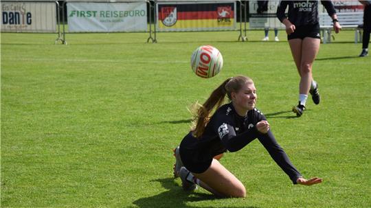 Faustballerin Monja Schlichting vom MTV Wangersen hechtet zum Ball und auf den Rasen.