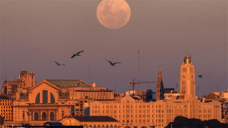 Montevideo, Uruguay: Vollmond schiebt sich über die Skyline