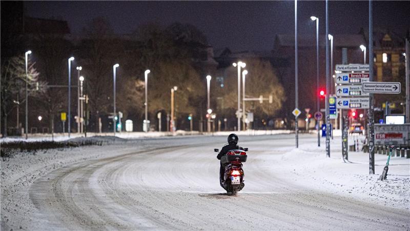 Motorroller kämpft sich am frühen Morgen durch Schnee im Stadtzentrum in Hannover