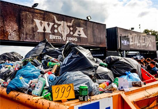 Müll stapelt sich in grossen Containern beim Wacken Open Air vor dem Eingang zum Festivalgelände. Auch die Metalszene versucht, nachhaltiger zu werden. Foto: Axel Heimken/dpa