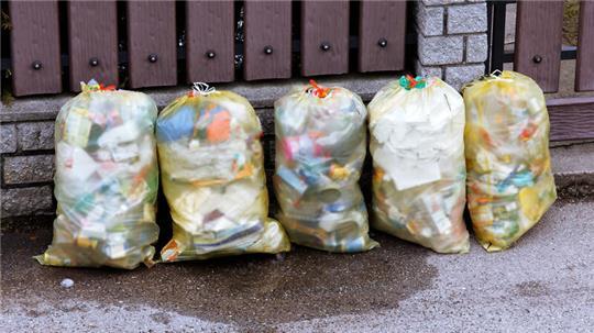 Müllsäcke mit Plastikmüll stehen zur Abholung bereit.