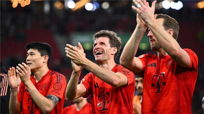 Münchens Münchens Minjae Kim (l-r), Thomas Müller und Münchens Harry Kane feiern nach dem Spiel gegen den FC Augsburg ihren 1:3-Sieg mit den Fans.