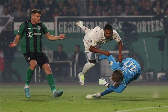 Münsters Torwart Johannes Schenk (r) im Kampf um den Ball mit Münchens Serge Gnabry (M), der sich dabei verletzt.