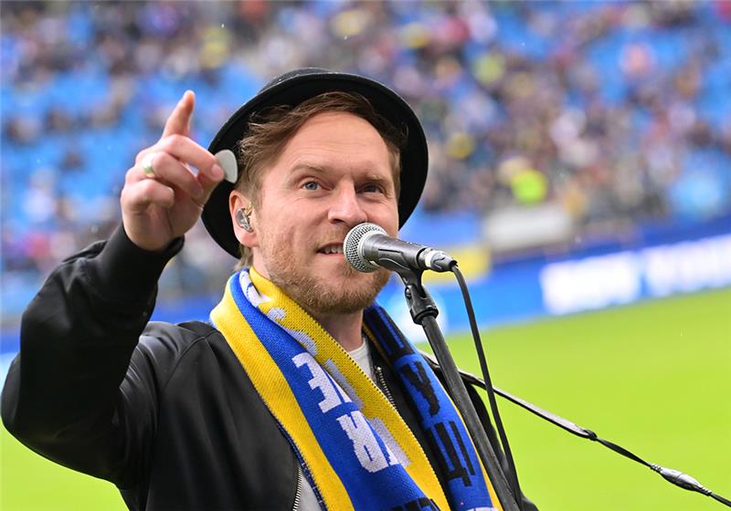 Musiker Johannes Oerding singt in der Halbzeitpause für die Zuschauer. Foto: Jonas Walzberg/dpa