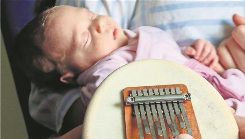 Musiktherapeutin Uta Jordan spielt Kalimba-Daumenklavier für Ida, die mit nur 2.200 Gramm Gewicht zur Welt kam. Die Klänge haben eine beruhigende Wirkung auf das Baby.
