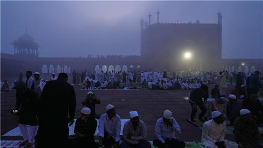Muslime warten im Morgennebel in der Jama Masjid in Neu Delhi auf das Eid al-Fitr-Gebet am Ende des heiligen Fastenmonats Ramadan.