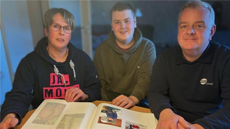 Mutter Nicole, Tim und Vater Horst Böckmann sehen sich gemeinsam das Familien-Fotoalbum an, in dem auch Bilder von großen Narben und schweren Operationen ihren Platz gefunden haben.