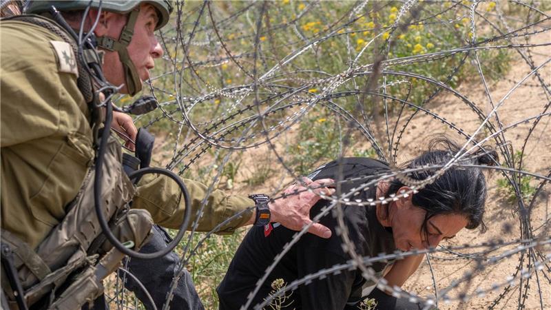 Mutter von Geisel versucht, Stacheldraht an Gaza-Grenze zu überwinden. 