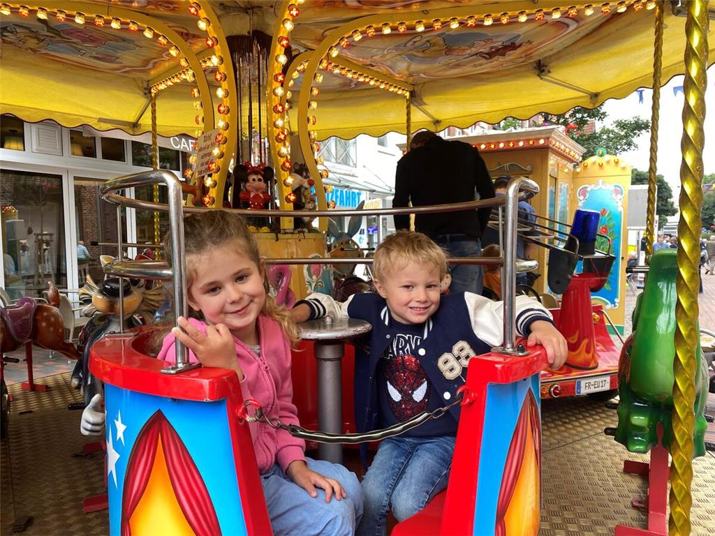 Mya und Alexander drehen eine Runde im Kinderkarussell.