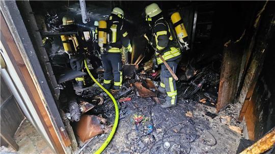 Nach Ablöschen des Feuers wird das verbrannte Inventar auseinandergezogen und ins Freie transportiert.