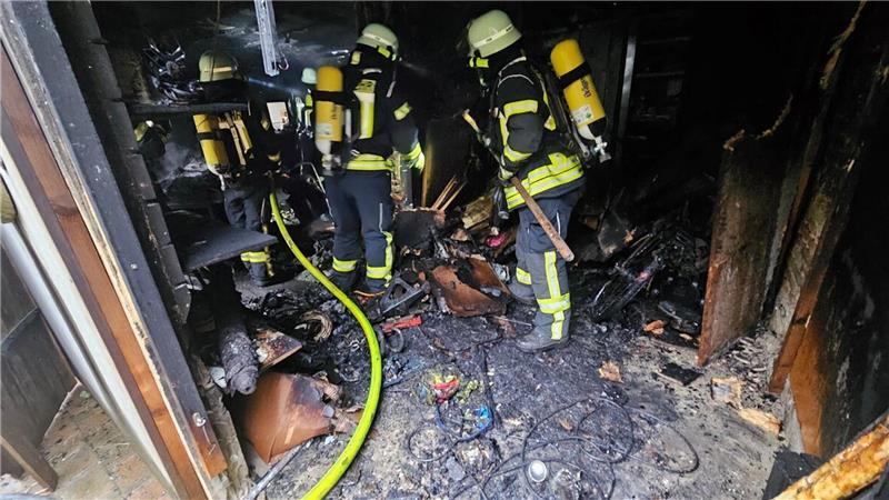 Nach Ablöschen des Feuers wird das verbrannte Inventar auseinandergezogen und ins Freie transportiert.