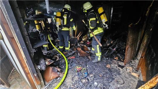 Nach Ablöschen des Feuers wird das verbrannte Inventar auseinandergezogen und ins Freie transportiert.
