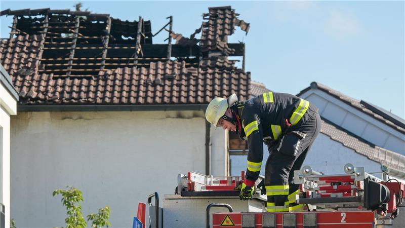 Nach Brand in München: Feuerwehrleute packen an einem Haus im Münchner Norden ihre Utensilien ein. 
