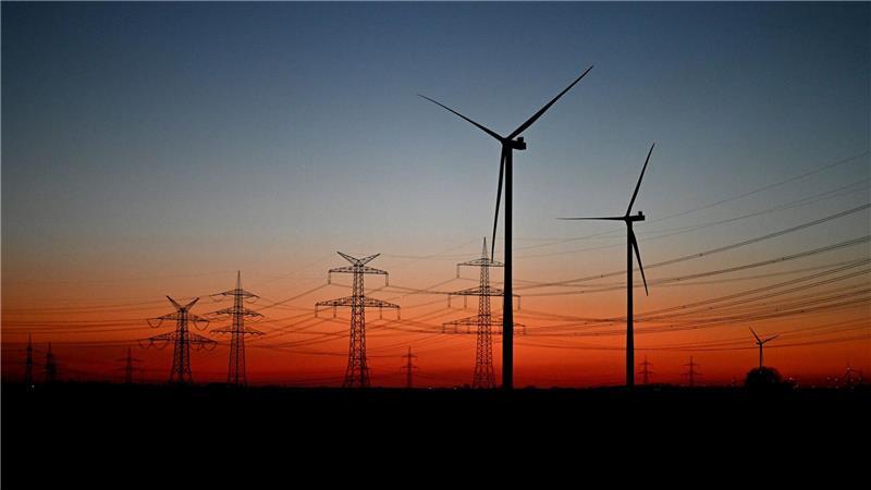 Nach Sonnenuntergang stehen Windräder auf einem Feld bei Pulheim.