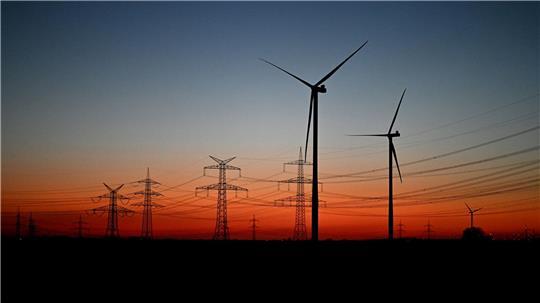 Nach Sonnenuntergang stehen Windräder auf einem Feld bei Pulheim.